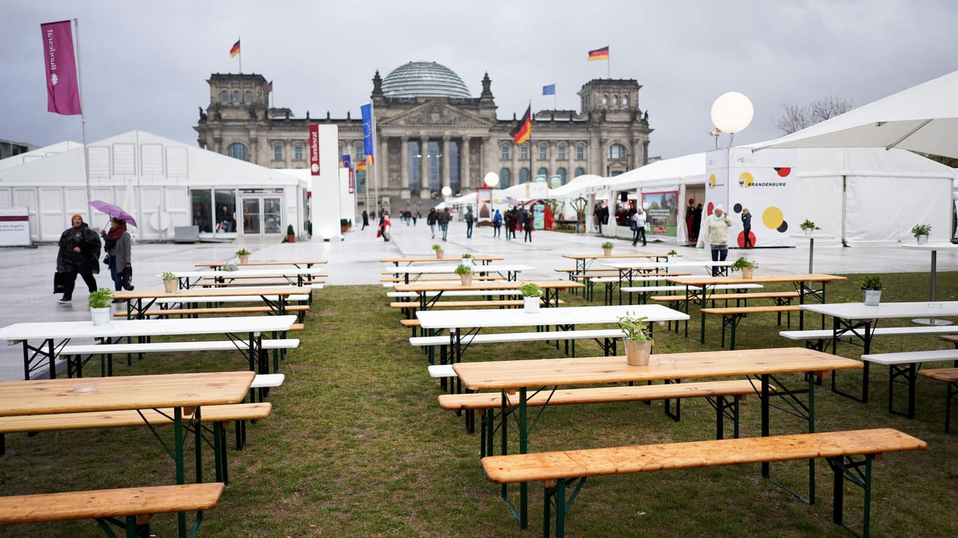 Berlin: Wegen des schlechten Wetters sind wenige Gäste bei den Feierlichkeiten zum Tag der Deutschen Einheit auf der Wiese vor dem Reichstagsgebäude.