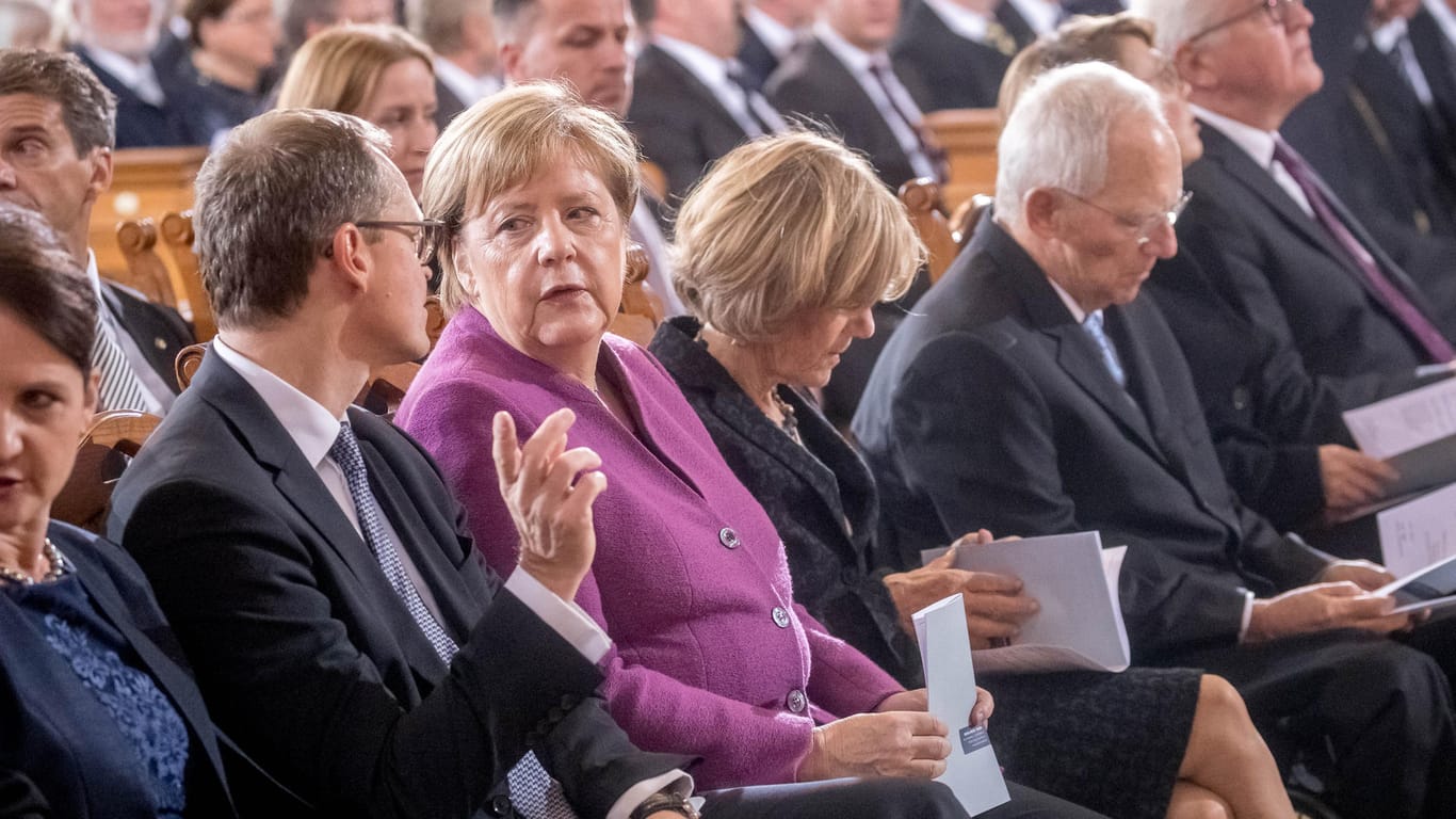 Michael Müller spricht mit Bundeskanzlerin Merkel bei den Feierlichkeiten zum Tag der Deutschen Einheit zu Beginn eines ökumenischen Gottesdienstes im Berliner Dom.