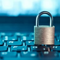 Ein Schloss auf einer Tastatur: Wer seine Online-Konten vor Hackern schützen will, braucht sichere Passwörter.
