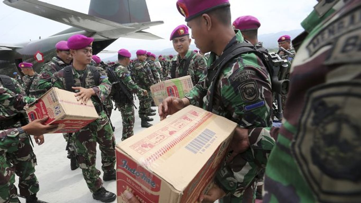 Indonesische Soldaten helfen am Flughafen Mutiara Sis Al-Jufri bei der Verteilung von Hilfsgütern.