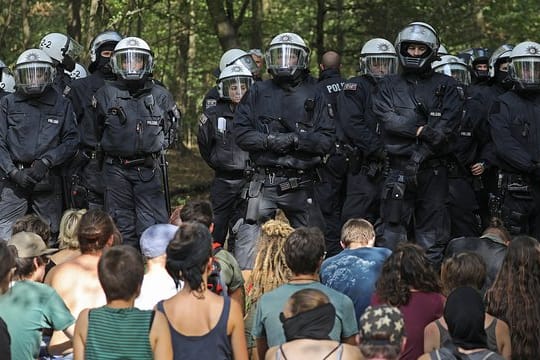 Aktivisten im Hambacher Forst vor einer Polizeikette.