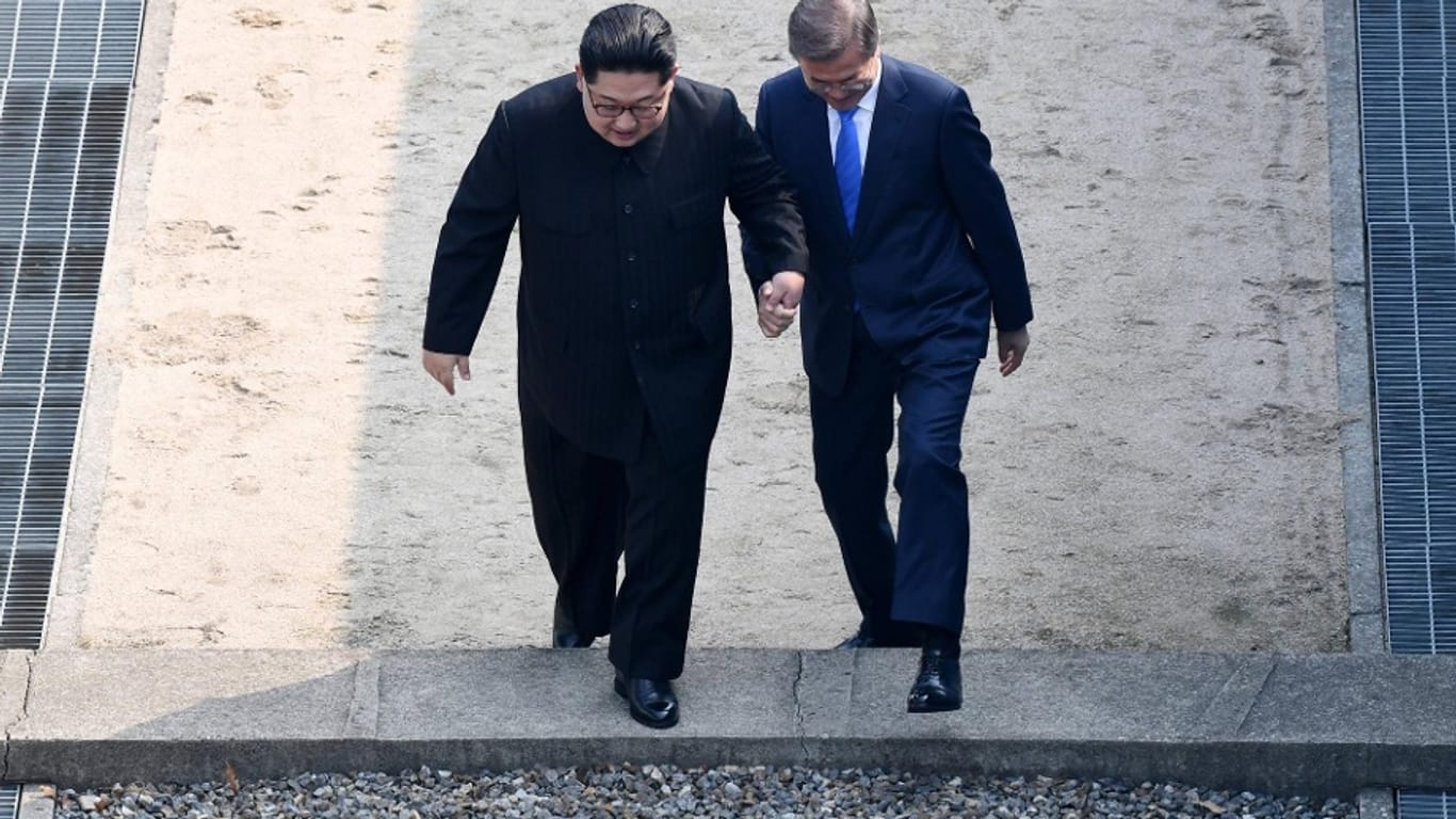 Der nordkoreanische Machthaber Kim Jong Un überschreitet gemeinsam mit Südkoreas Präsident Moon Jae-in die innerkoreanische Grenze.