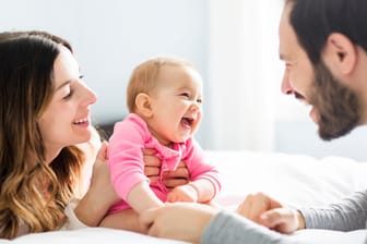 Baby mit Eltern: Kinder brauchen das Gefühl, gewollt und gewünscht zu sein.