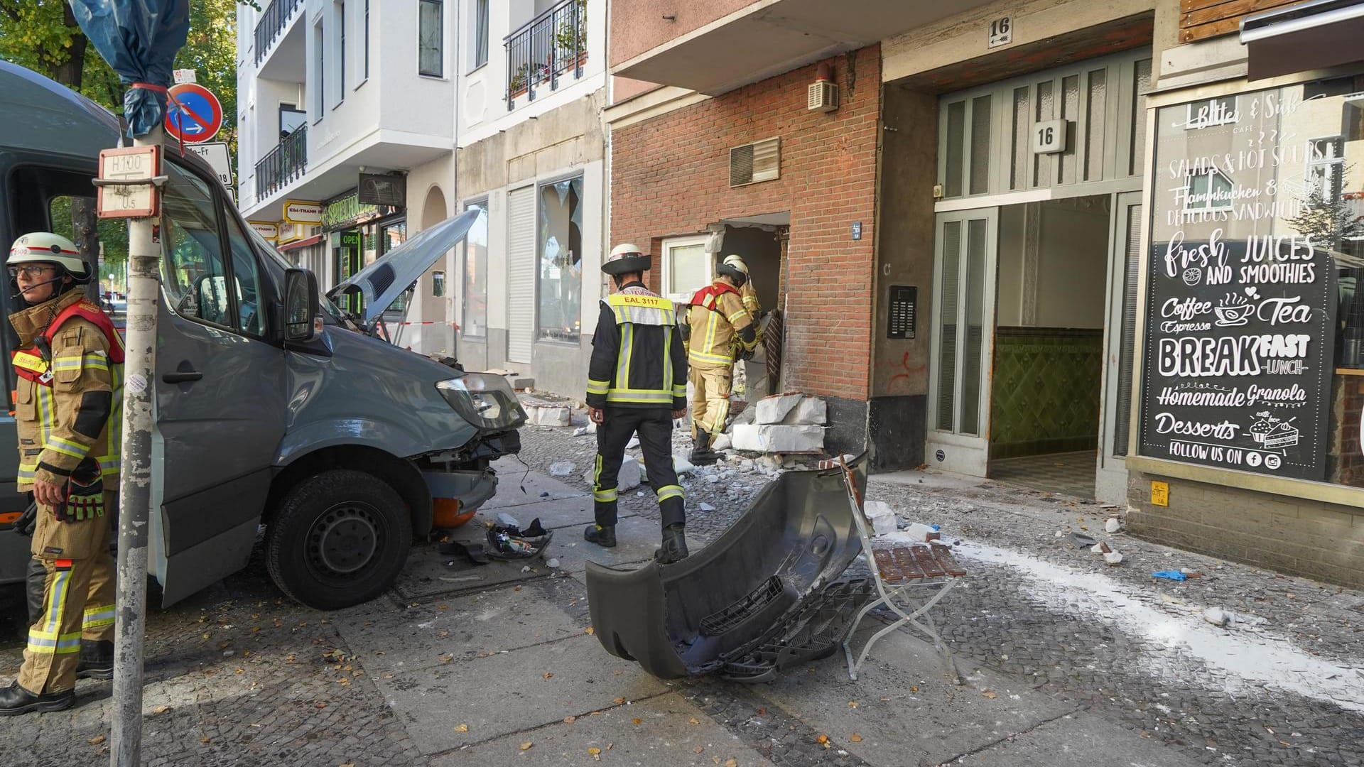 Einsatzkräfte der Feuerwehr stehen an einer beschädigten Hauswand und einem Transporter: Ein Fahrzeug ist Berlin-Charlottenburg in eine Menschengruppe gefahren.