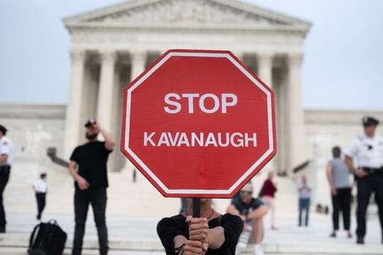 Eine Demonstrantin hält in Washington ein Schild, mit der Aufschrift "Stop Kavanaugh" hoch.