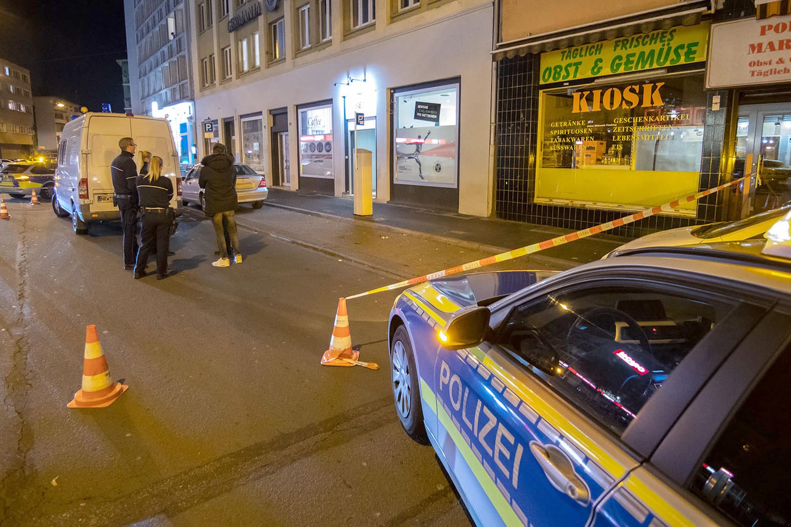 Einsatzwagen und Einsatzkräfte der Polizei sperren den Tatort ab: In Hagen ist ein Mann vor einem Wettbüro in der Innenstadt angeschossen worden. Die Mordkommission hat die Ermittlungen übernommen, teilte die Polizei mit.