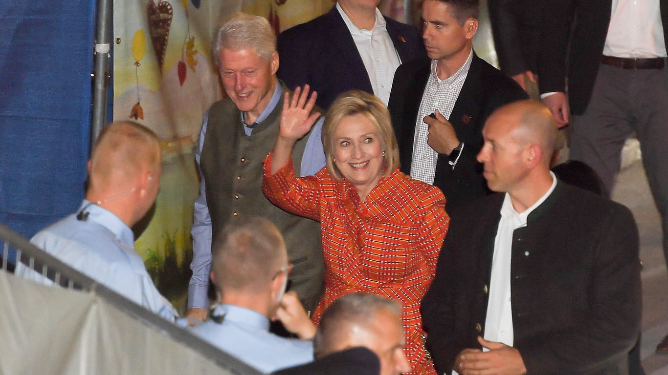 Bill und Hillary Clinton: Mit ihrer Entourage und guter Laune kommen sie am Käfer-Zelt an.