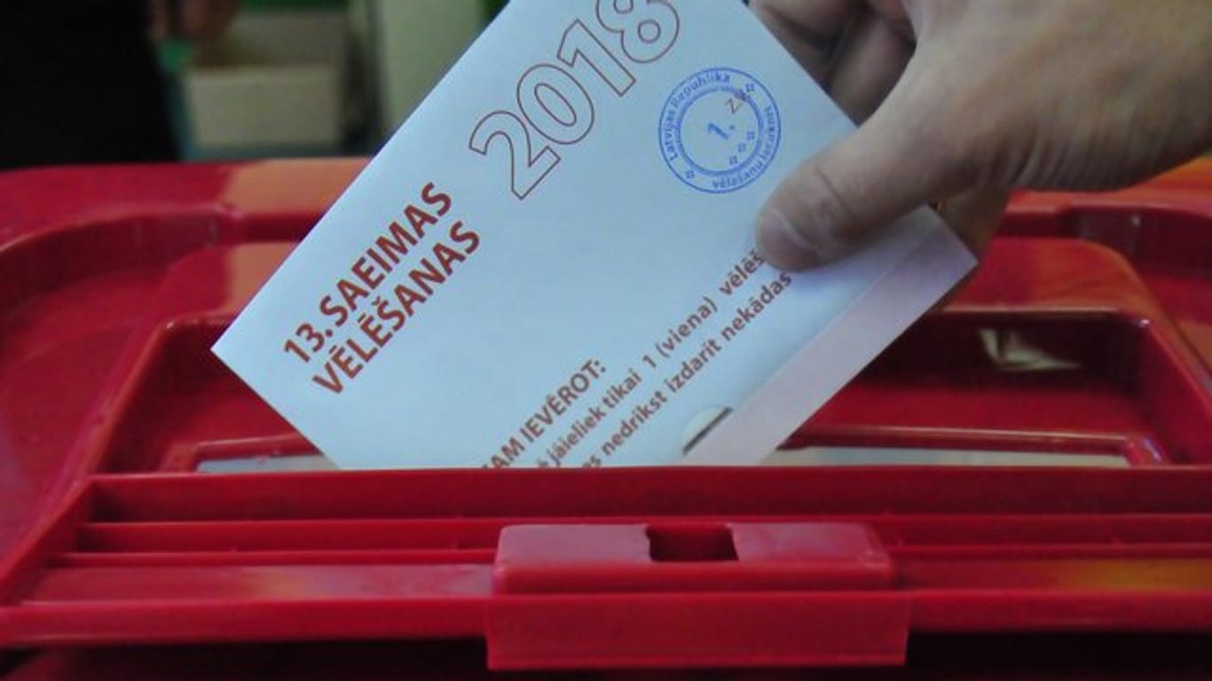 Abgabe eines Wahlscheins in einem Wahllokal in Riga.