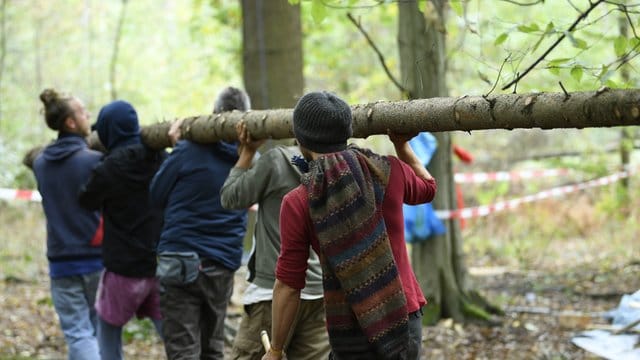 Neubaugebiet im Hambacher Forst: Aktivisten schleppen einen Baumstamm.