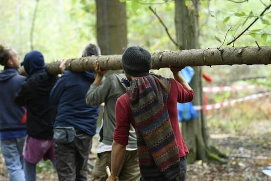 Neubaugebiet im Hambacher Forst: Aktivisten schleppen einen Baumstamm.