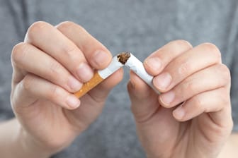 Ein Mann zerbricht eine Zigarette: Vermeiden Sie den Montag, wenn Sie mit dem Rauchen aufhören wollen.
