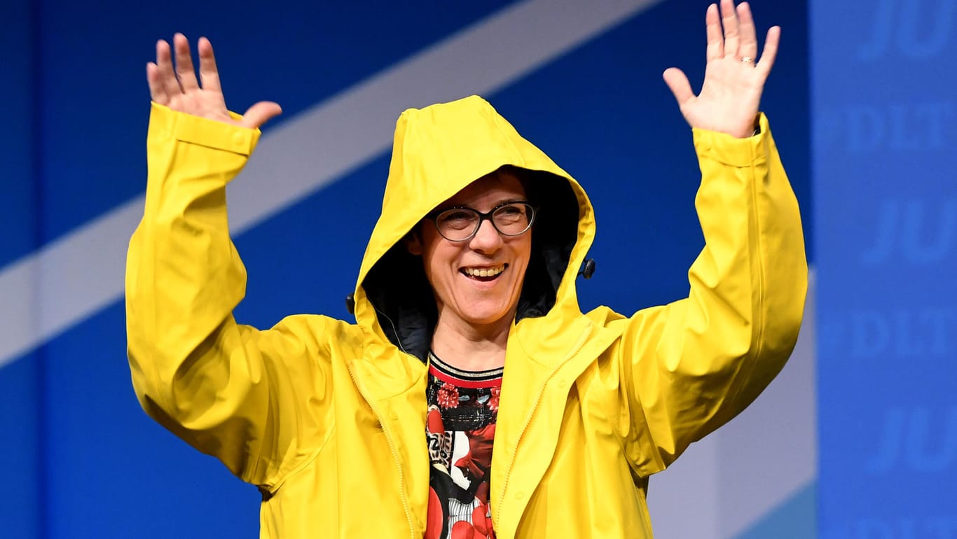 Annegret Kramp-Karrenbauer probiert das Geschenk der Jungen Union auf dem Deutschlandtag gleich auf der Bühne an: eine Regenjacke.