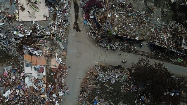 Diese Luftaufnahme zeigt zerstörte Gebäude um eine Straßenkreuzung in Palu.