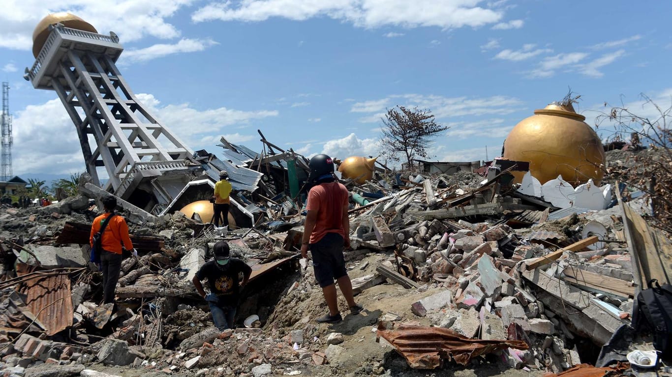Menschen stehen vor den Trümmern einer Moschee: Rund 5000 Menschen werden nach den Erdbeben und dem Tsunami in Indonesien noch immer vermisst.