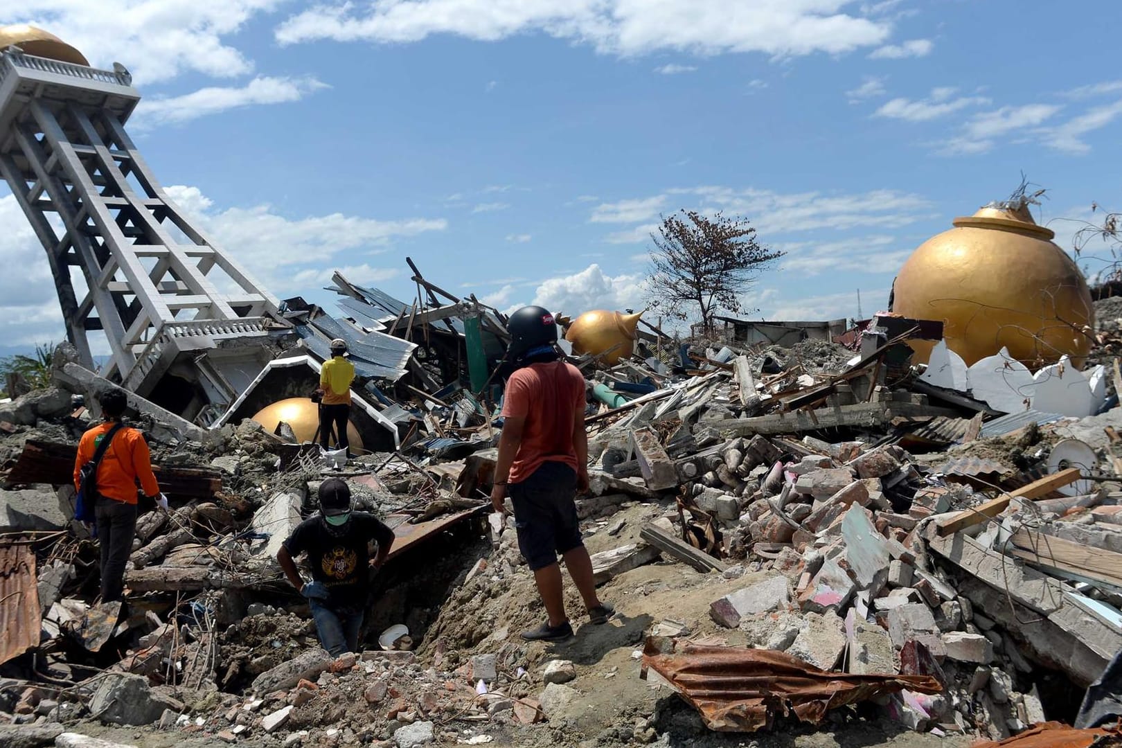 Menschen stehen vor den Trümmern einer Moschee: Rund 5000 Menschen werden nach den Erdbeben und dem Tsunami in Indonesien noch immer vermisst.
