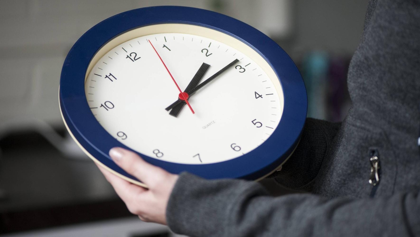 Eine Frau hält eine Wanduhr (Symbolbild): In den EU-Staaten formiert sich Widerstand gegen die Pläne zur Abschaffung der Zeitumstellung.