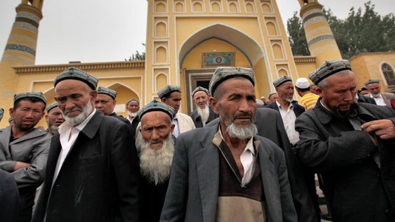 Muslimische Männer der Uiguren kommen aus der Id Kah Moschee nach den Freitagsgebeten.