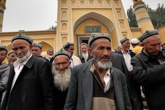 Muslimische Männer der Uiguren kommen aus der Id Kah Moschee nach den Freitagsgebeten.