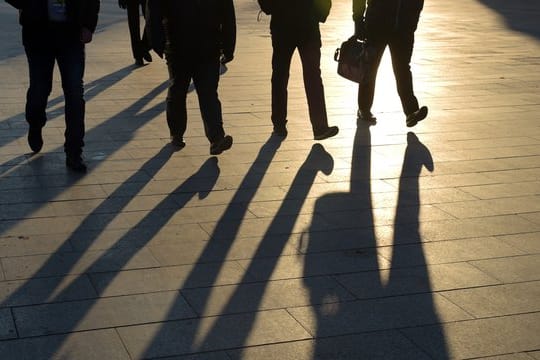 Im Sonnenschein gehen Fußgänger durch die City-West in Berlin.