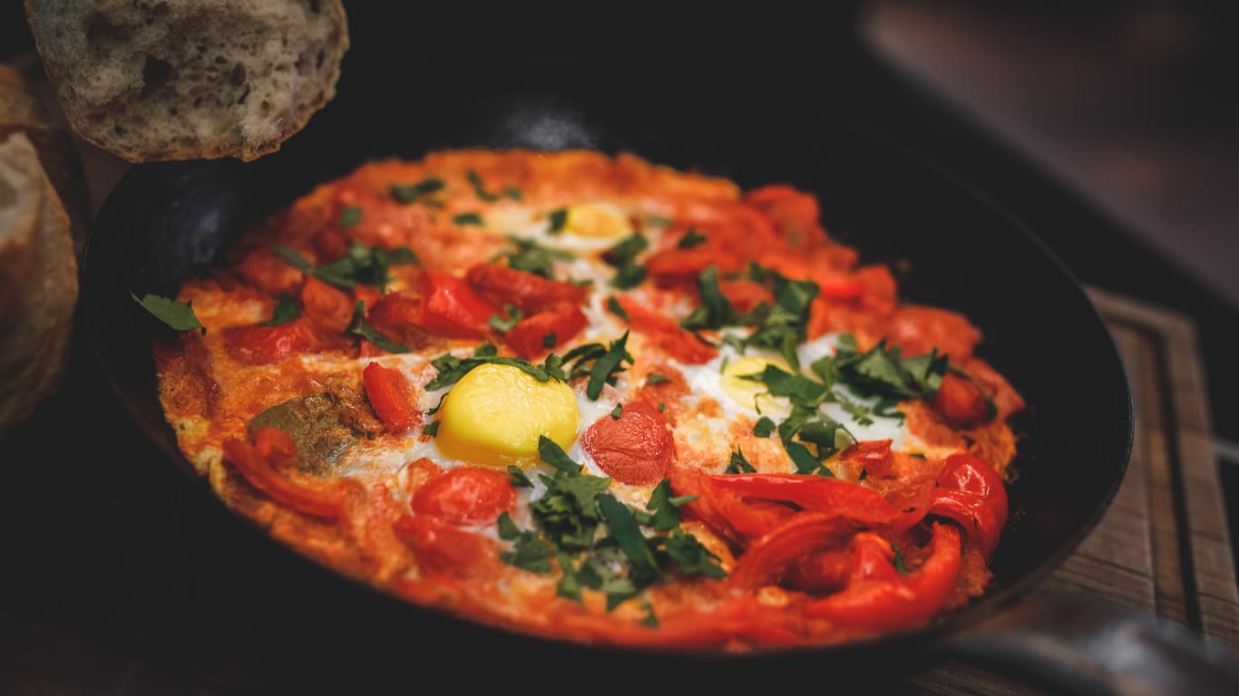 In Israel wird Schakschuka häufig zum Frühstück gegessen: ein Schmorgericht aus Tomaten, Paprika, Eiern und Kräutern.