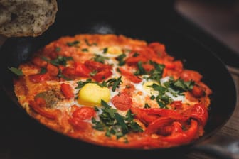 In Israel wird Schakschuka häufig zum Frühstück gegessen: ein Schmorgericht aus Tomaten, Paprika, Eiern und Kräutern.