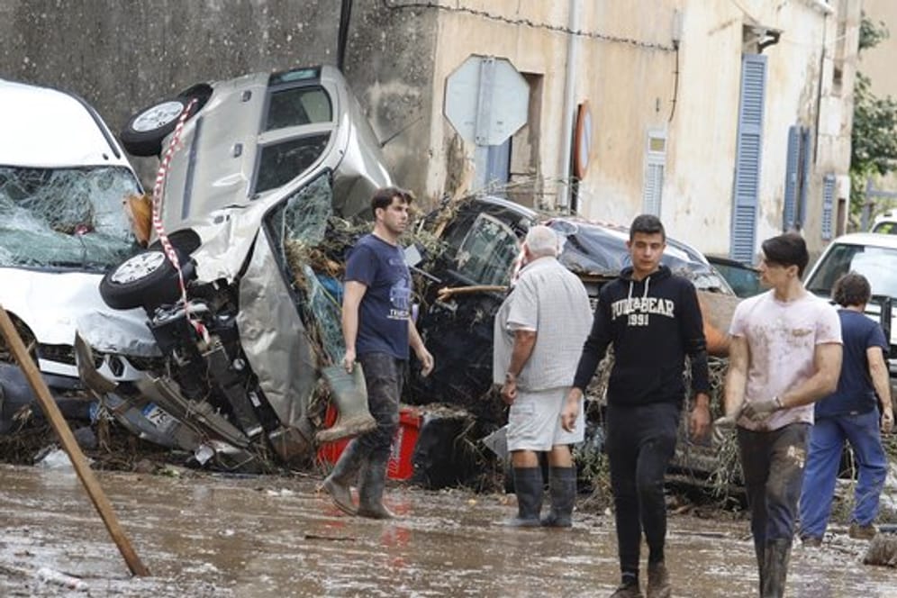 Einwohner von Sant Llorenc des Cardassar gehen nach dem schweren Unwetter an Autowracks vorbei.