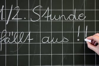 Eine Lehrerin schreibt in einer Grundschule an die Tafel: An Deutschlands Schulen fehlen innerhalb von zehn Jahren nach offizieller Prognose 18.000 Lehrer.