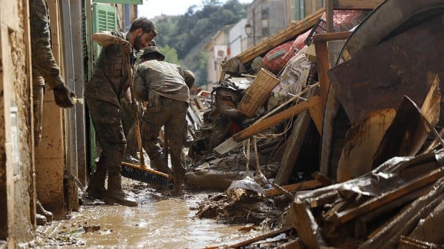 Spanische Soldaten reinigen eine verschlammte Straße in Sant Llorenc des Cardassar.