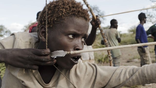 Osama, 15, Angehöriger des Volkes der Hadza, beim Bogenschießen. Osama, 15, Angehöriger des Volkes der Hadza, beim Bogenschießen.