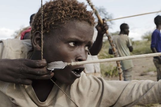 Osama, 15, Angehöriger des Volkes der Hadza, beim Bogenschießen.