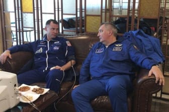 Der US-Astronaut Nick Hague (l) und Dmitri Rogosin, Leiter der russischen Raumfahrtorganisation Roskosmos, nach der Notlandung der Sojus-Kapsel in Schesqasghan (Kasachstan).