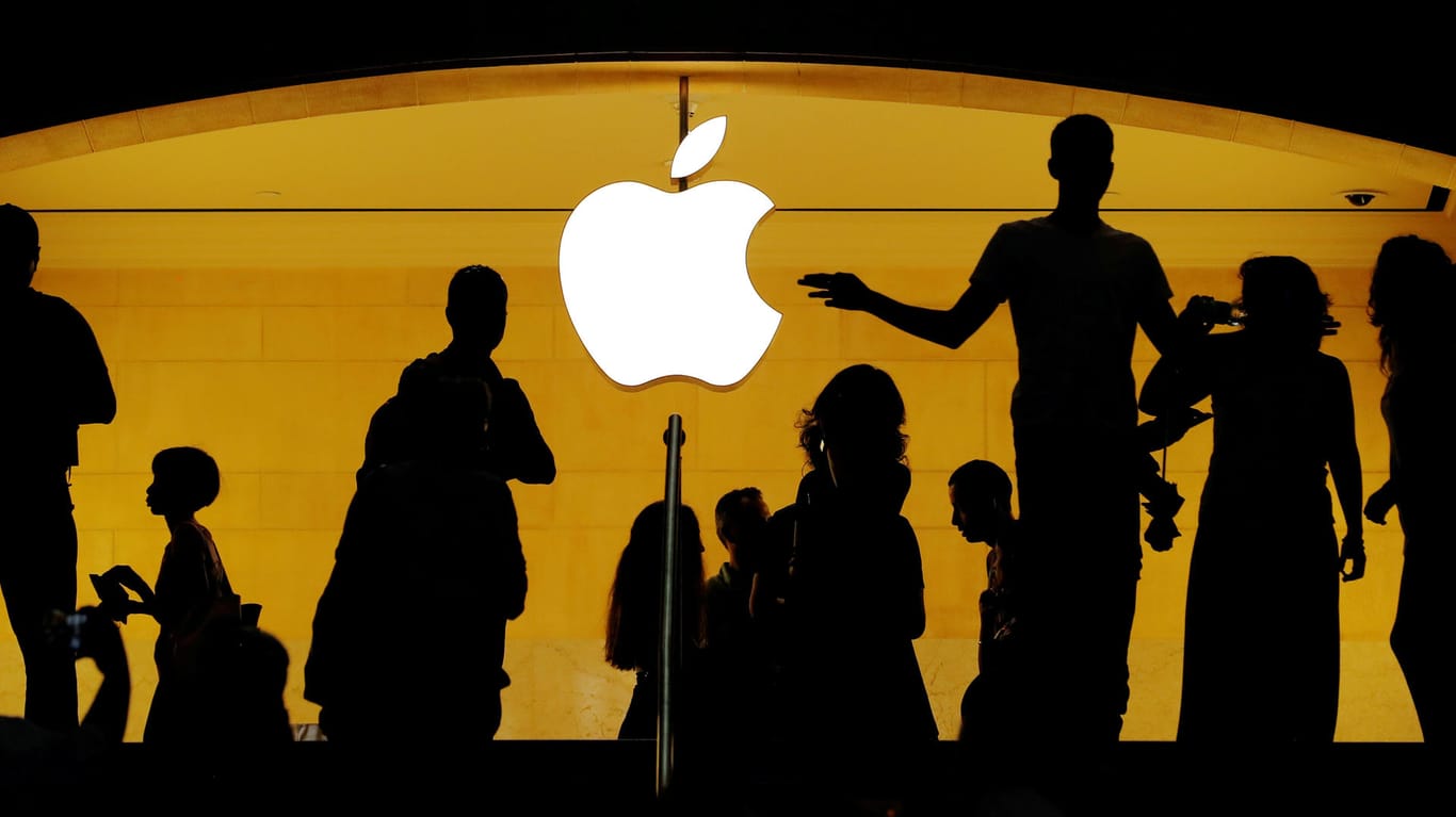Menschliche Silhouetten vor dem Apple-Logo: Der iPhone-Konzern hat im Patentstreit mit dem Chip-Hersteller Qualcomm einen Teilsieg errungen.