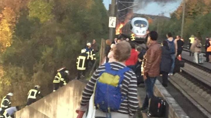 Evakuierung von den Gleisen: Feuerwehrleute legen an einer Böschung Leitern aus und helfen den Menschen aus ICE511 den Hügel hinunter zum Sammelplatz.