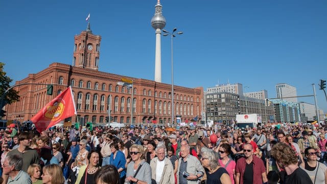 Teilnehmer der Kundgebung gegen Rassismus ziehen am Roten Rathaus vorbei.