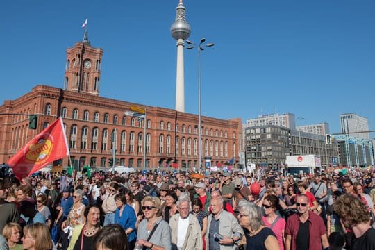 Teilnehmer der Kundgebung gegen Rassismus ziehen am Roten Rathaus vorbei.