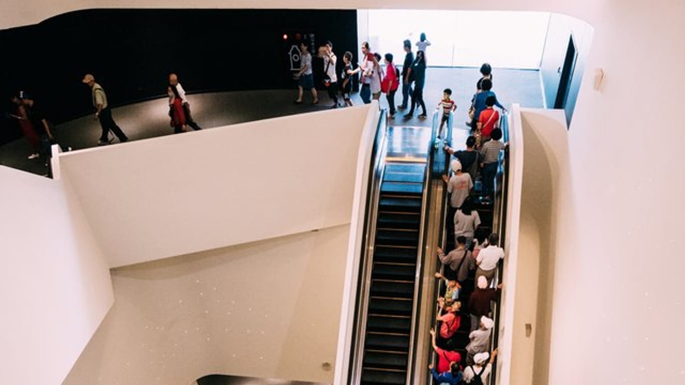 Besucher fahren nach der Eröffnung des weltweit größten Zentrums für darstellende Künste unter einem Dach in der südtaiwanesischen Hafenstadt Kaohsiung auf einer Rolltreppe nach oben.