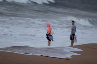 Paar am Strand von Carcavelos, Portugal: In der Nacht hat Sturm "Leslie" die Küste erreicht und Böen von 100 km/h gebracht.