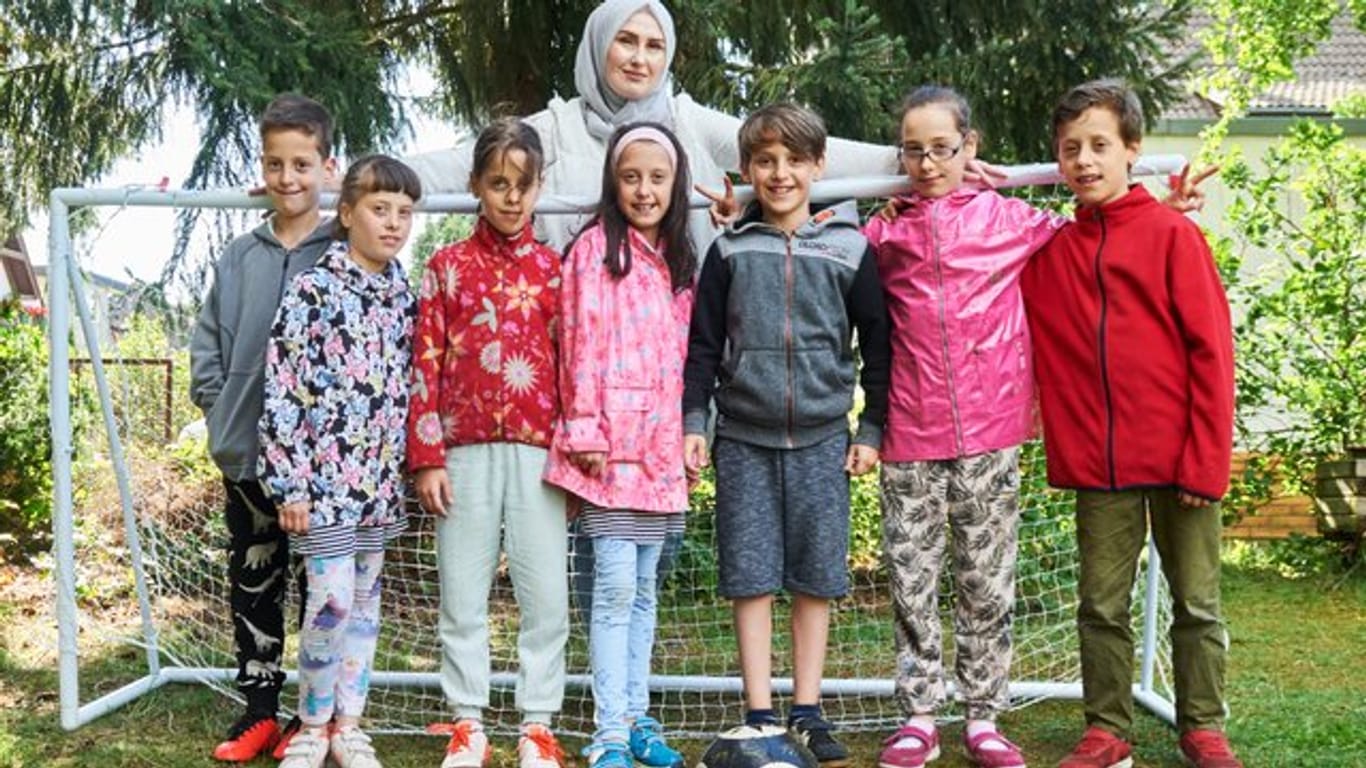 Die Sechslinge (l-r) Ahmed, Zehra, Zeynep, Rana, Malik-Musa, Esma, Adem aus Berlin stehen mit ihrer Mutter Roksana und dem ein Jahr jüngeren Bruder.