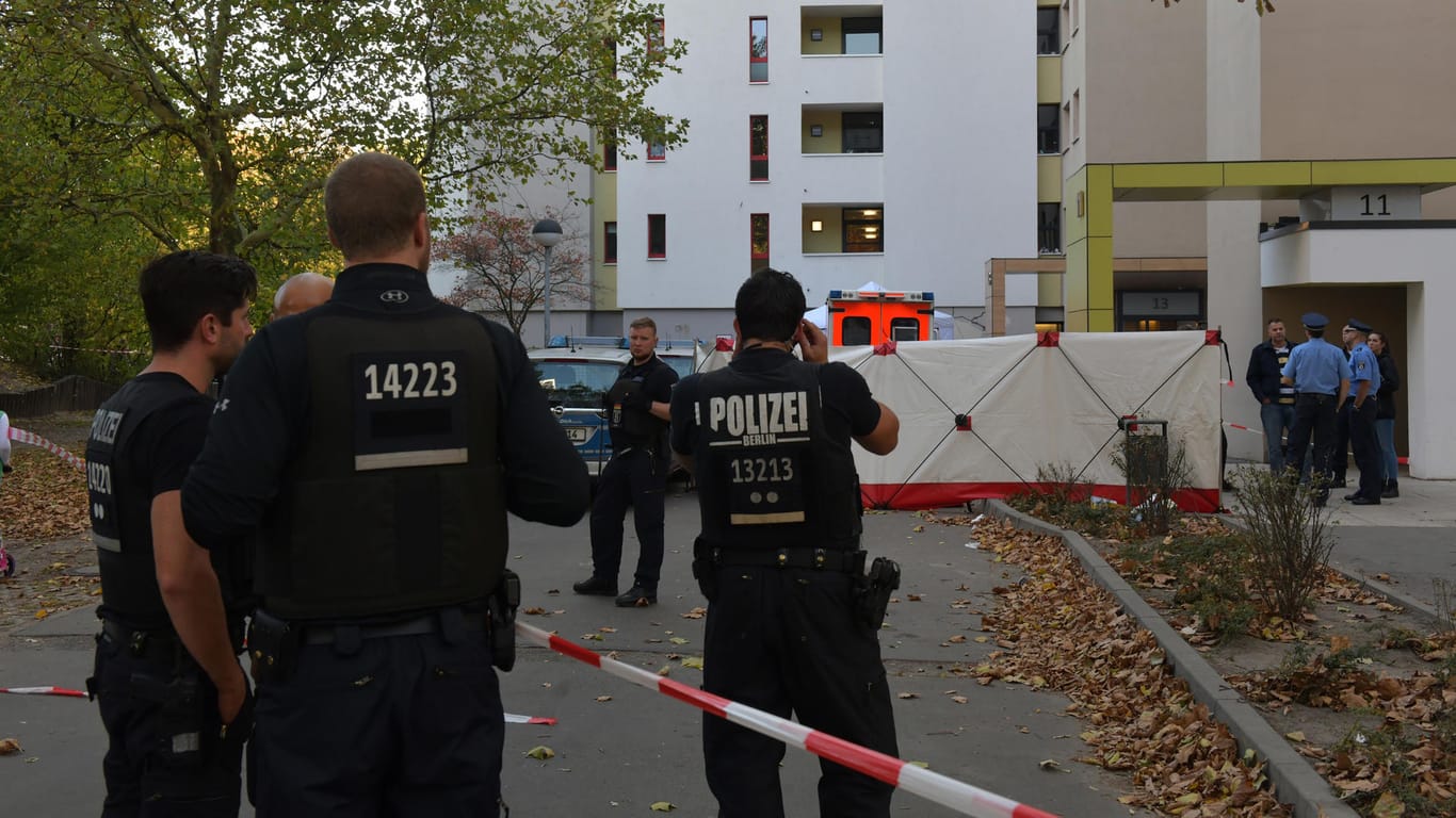 Polizisten stehen vor einem Hochhaus im Märkischen Viertel in Berlin. Dort wurde ein acht Jahre alter Junge auf seinem Fahrrad von einem Gegenstand getroffen und tödlich verletzt.