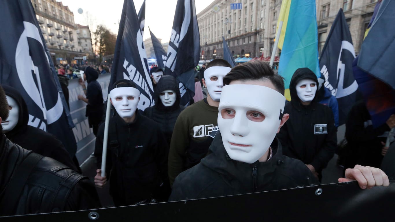 Teilnehmer der Demonstration gehen mit Masken und Fahnen durch die ukrainische Hauptstadt: Die Demonstranten haben an die Gründung der Ukrainischen Aufstandsarmee vor 76 Jahren erinnert.