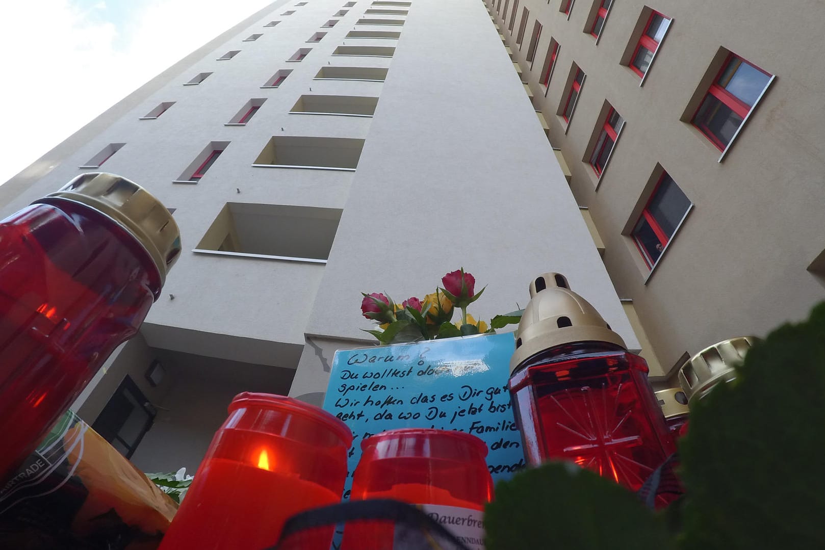 Der Tatort in Berlin: Blumen, Kerzen und Karten wurden vor einem Hochhaus an der Tiefenseer Straße im Märkischen Viertel abgelegt.