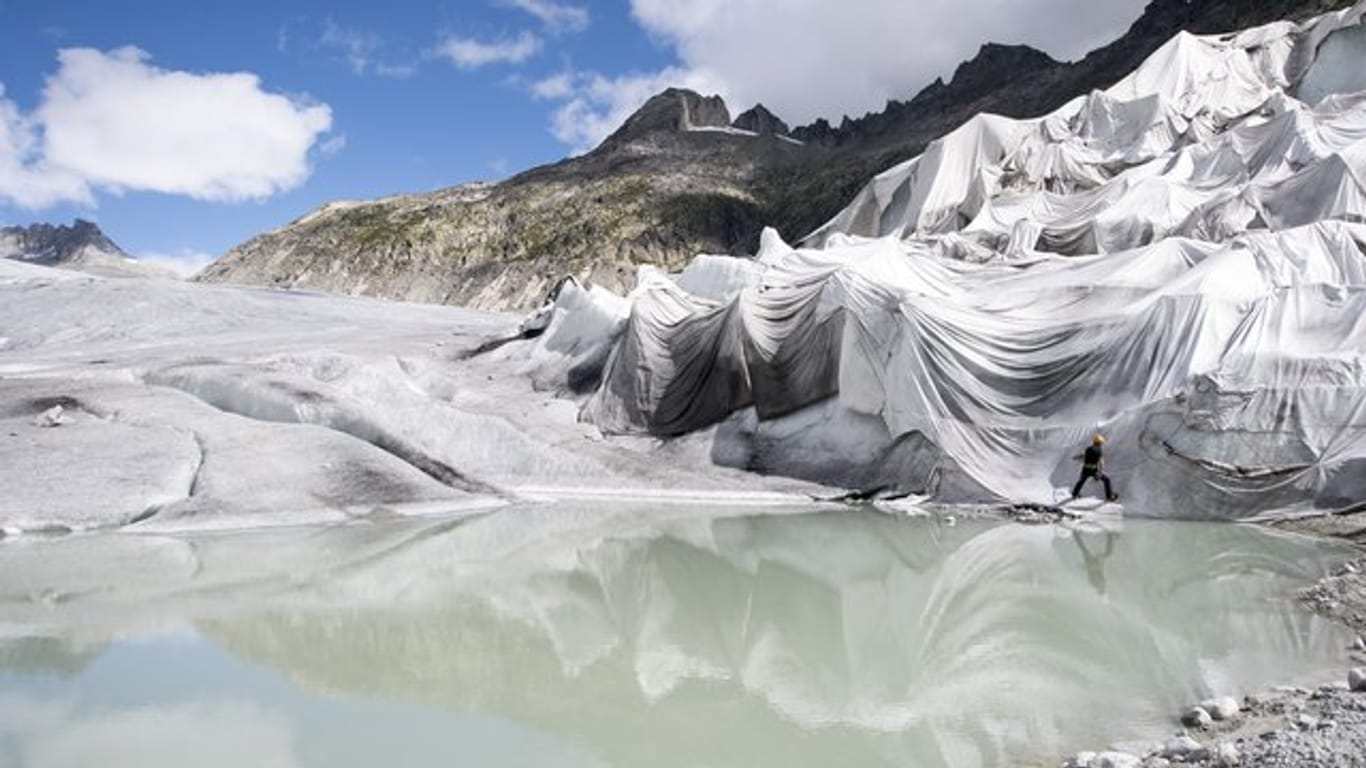 Arbeiter befestigen weiße Spezialdecken am Rhonegletscher, um den ältesten Gletscher der Alpen vor dem Schmelzen zu bewahren.
