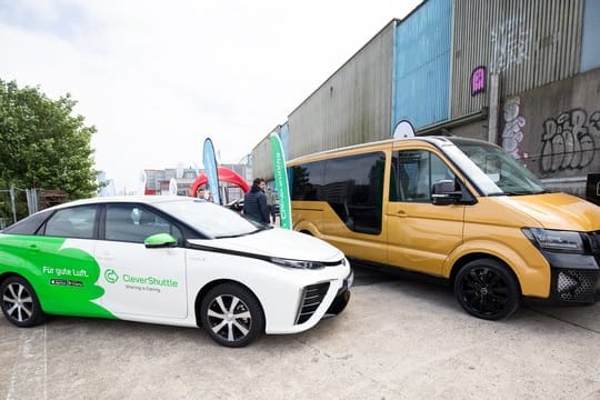 Ein Elektro-Sammeltaxi der VW-Tochter Moia und ein Fahrzeug von Clever Shuttle (l) auf dem New Mobility Day in Hamburg.