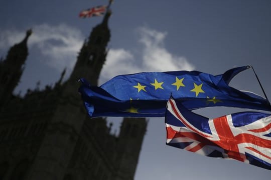 Eine EU-Flagge und der Union Jack vor dem Parlament in London.