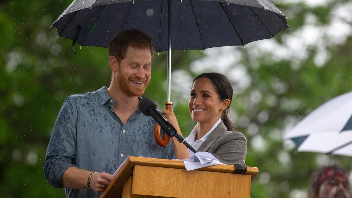 Prinz Harry hält eine Rede: Herzogin Meghan den Schirm.