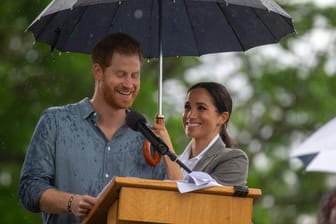 Prinz Harry hält eine Rede: Herzogin Meghan den Schirm.