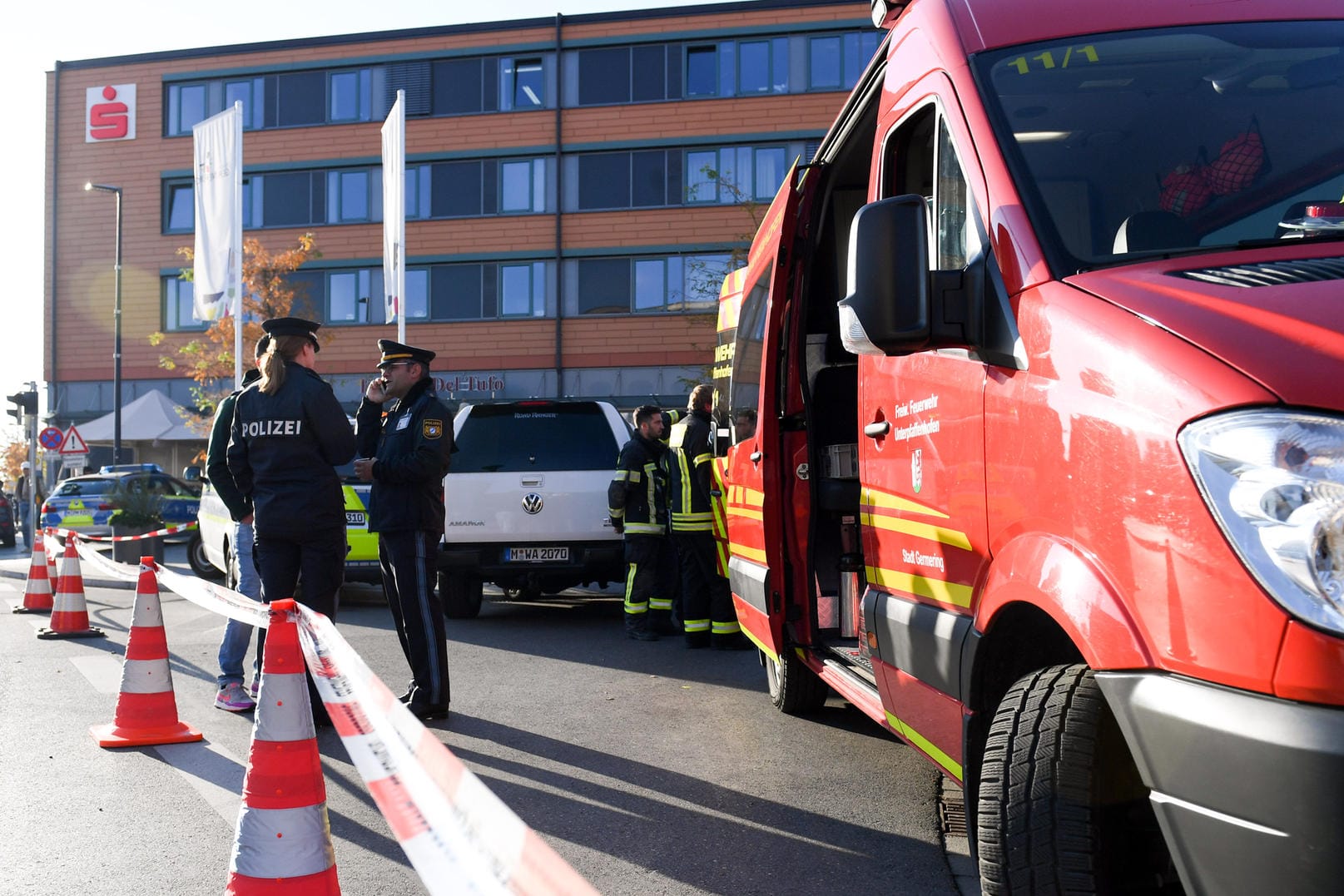 Polizisten arbeiten am abgesperrten Tatort: Ermittler hatten die Tatverdächtigen zuvor observiert, sodass sie eingreifen konnten, kurz bevor die Männer die Bank betreten wollten.