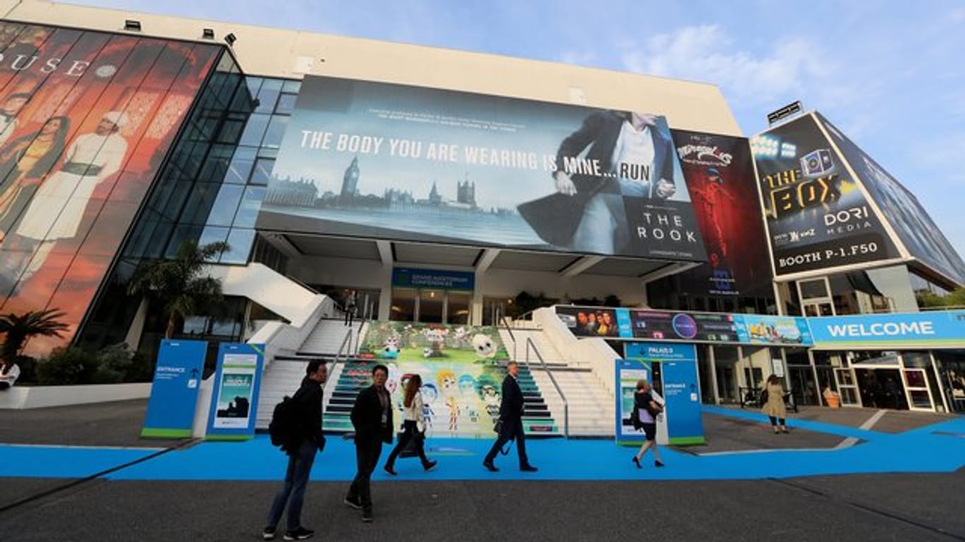 Besucher spazieren vor dem Festival-Palais der TV-Messe MIPCOM in Cannes.