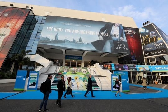 Besucher spazieren vor dem Festival-Palais der TV-Messe MIPCOM in Cannes.