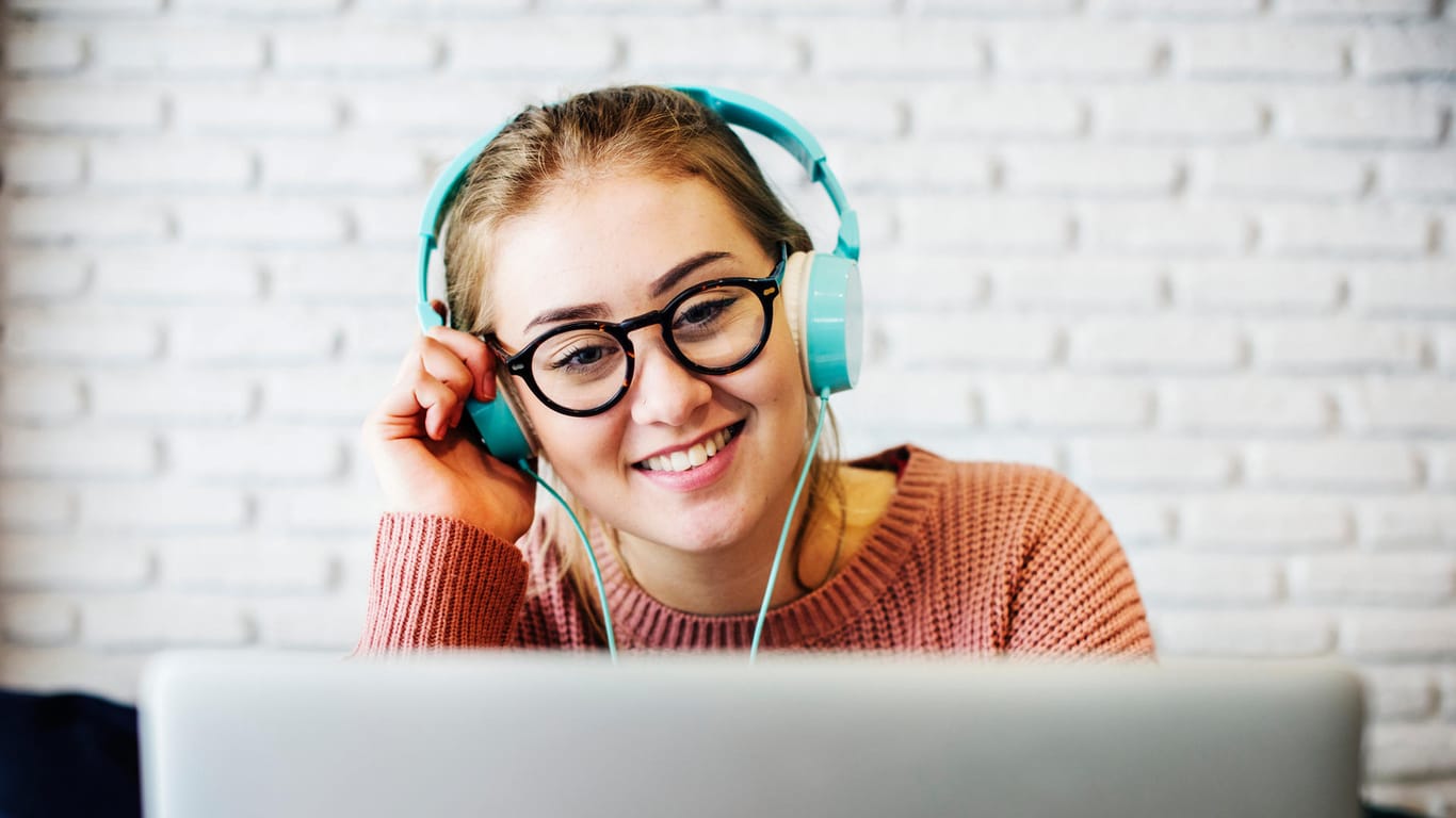 Eine Frau hört Musik am Computer: Die Software "Winamp" soll 2019 in einer neuen Version erscheinen.